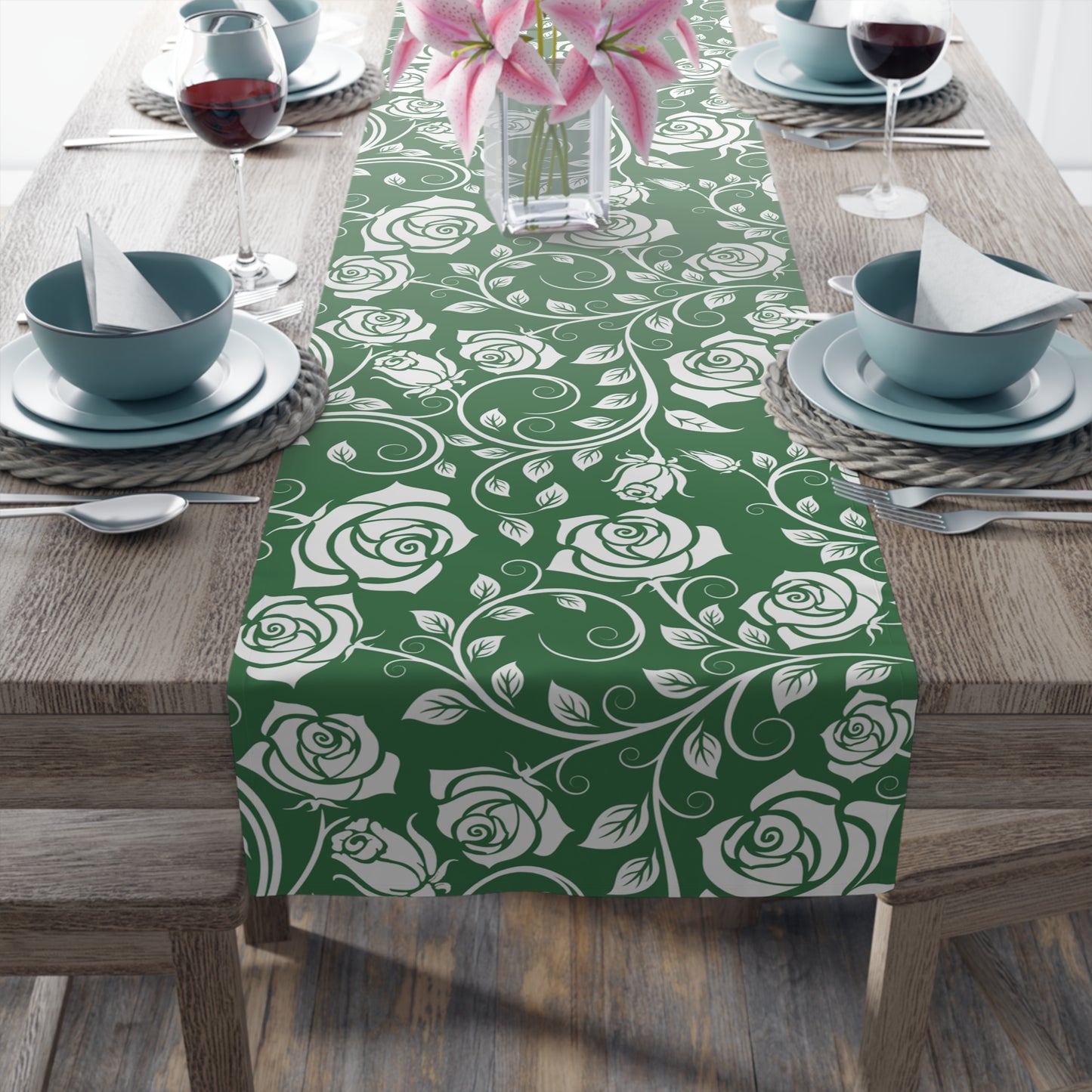 Green table runner with white rose pattern on a wooden table