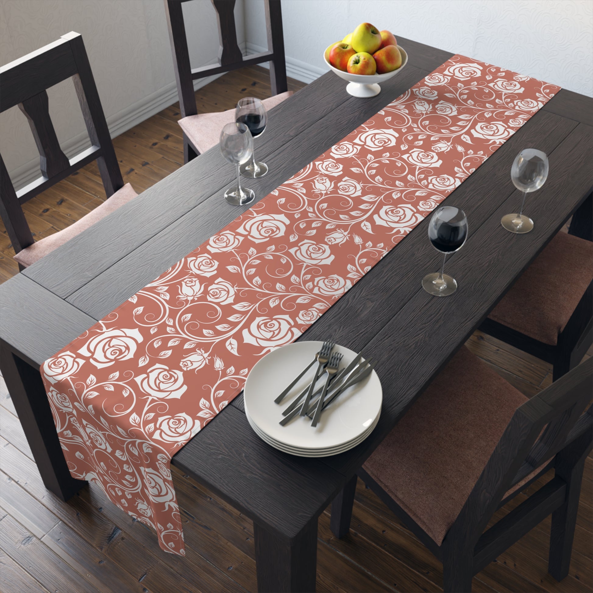 Dining table with a red and white floral-patterned cotton table runner, plates, and glasses.