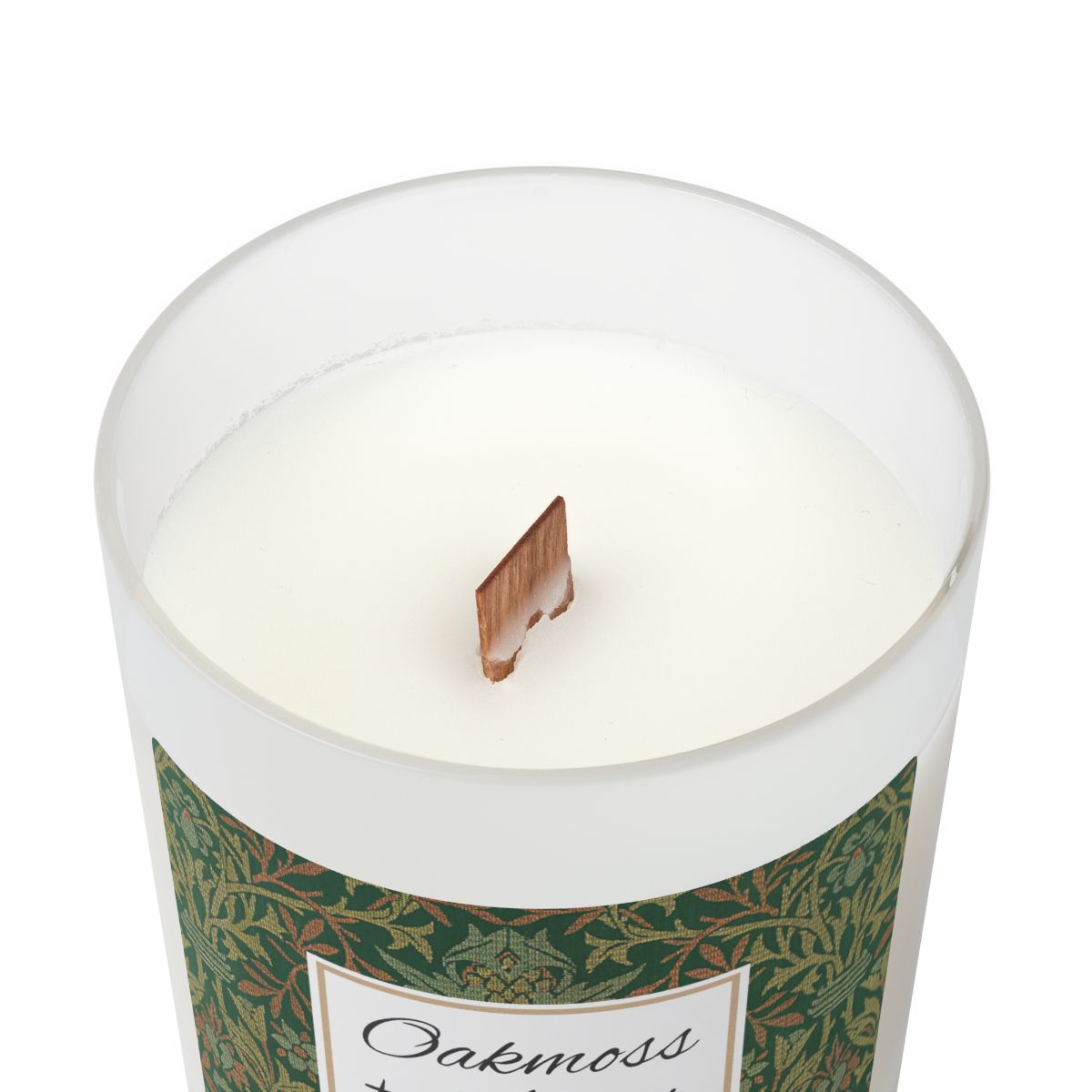 Wood wick Oakmoss & Amber candle  in a frosted glass jar with a green decorative label featuring the illustration by William Morris "Flower Garden" on a white background