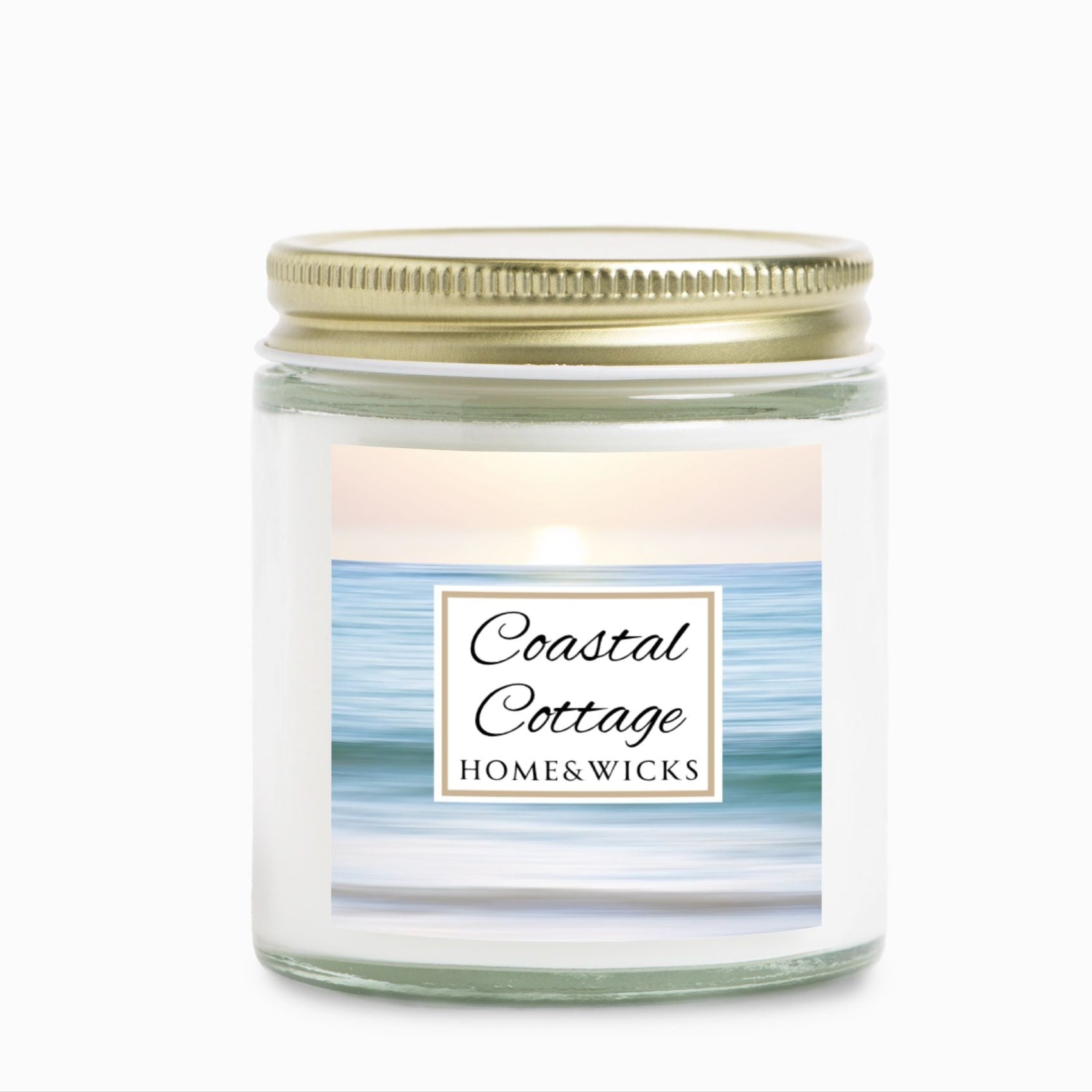 Coastal Cottage candle jar with a label reading 'Coastal Cottage' by 'Homes & Wicks' with a calm ocean shore image on a white background