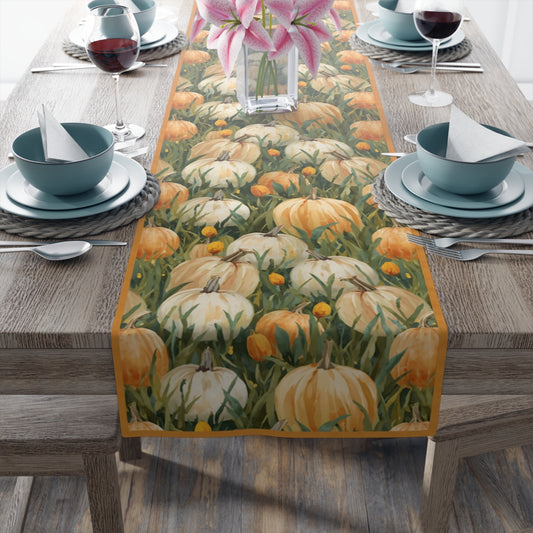 Table setting with a decorative pumpkin-themed table runner on a wooden table.